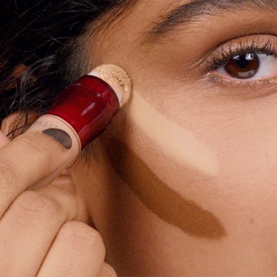 Femme appliquant Instant Anti-Age Eraser au-dessus de sa pommette